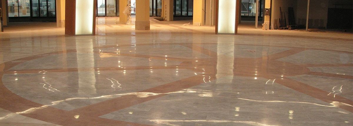 Una gran sala con suelo de mármol y columnas.