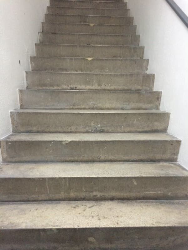Un conjunto de escaleras de hormigón que conducen a una pared blanca.