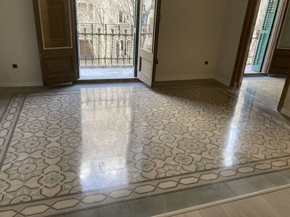 Una habitación con suelo de baldosas y balcón.