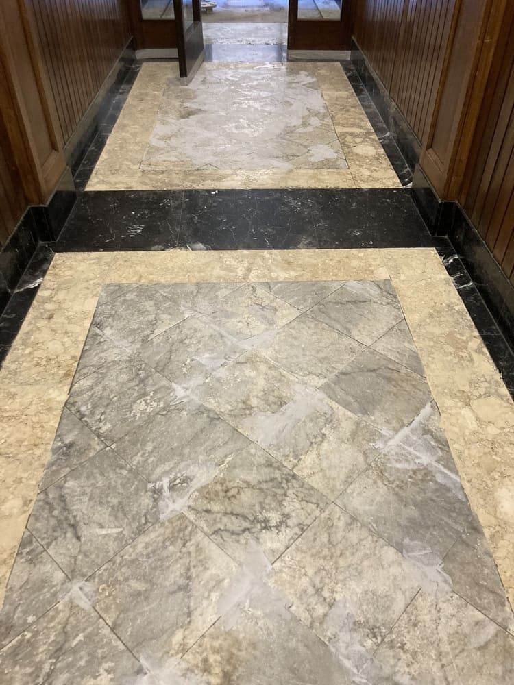 Un pasillo con suelo de mármol y pared de madera.