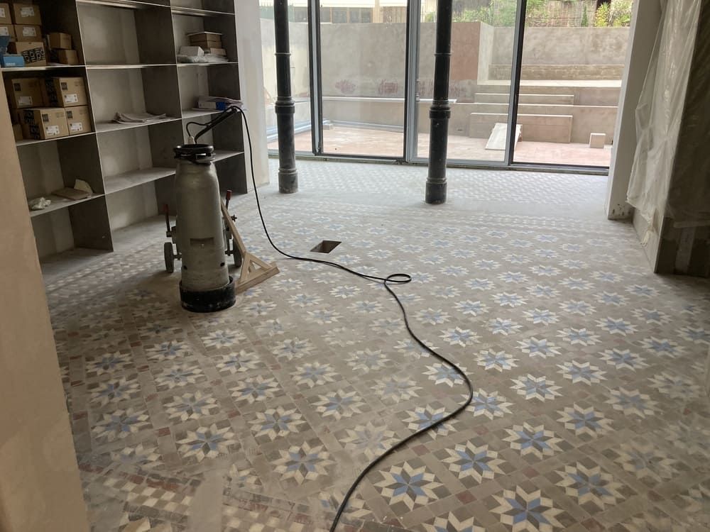 Una aspiradora está colocada sobre un suelo de baldosas en una habitación.