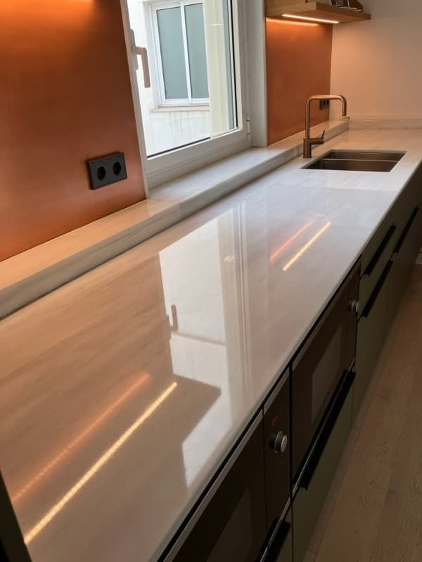 Un mostrador de cocina con un fregadero y una ventana.