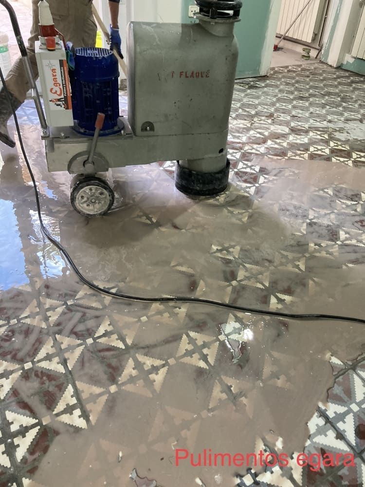 Una máquina está puliendo un piso de baldosas en una habitación.