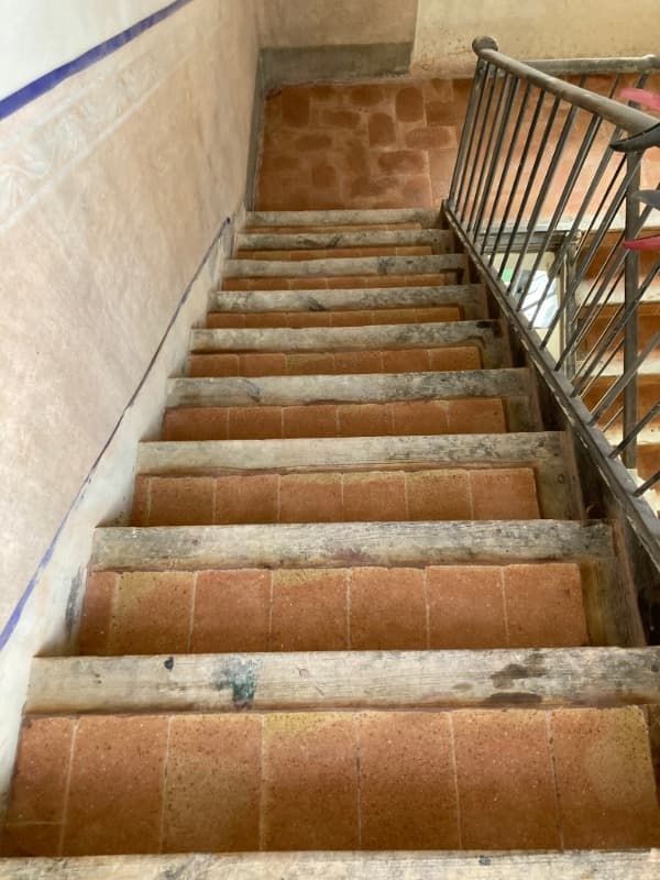 Una escalera con escalones de madera y barandilla de metal.