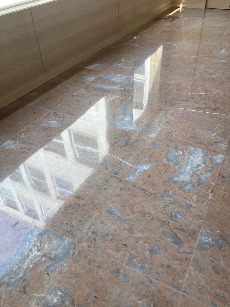 Un suelo de mármol con el reflejo de un edificio en él.