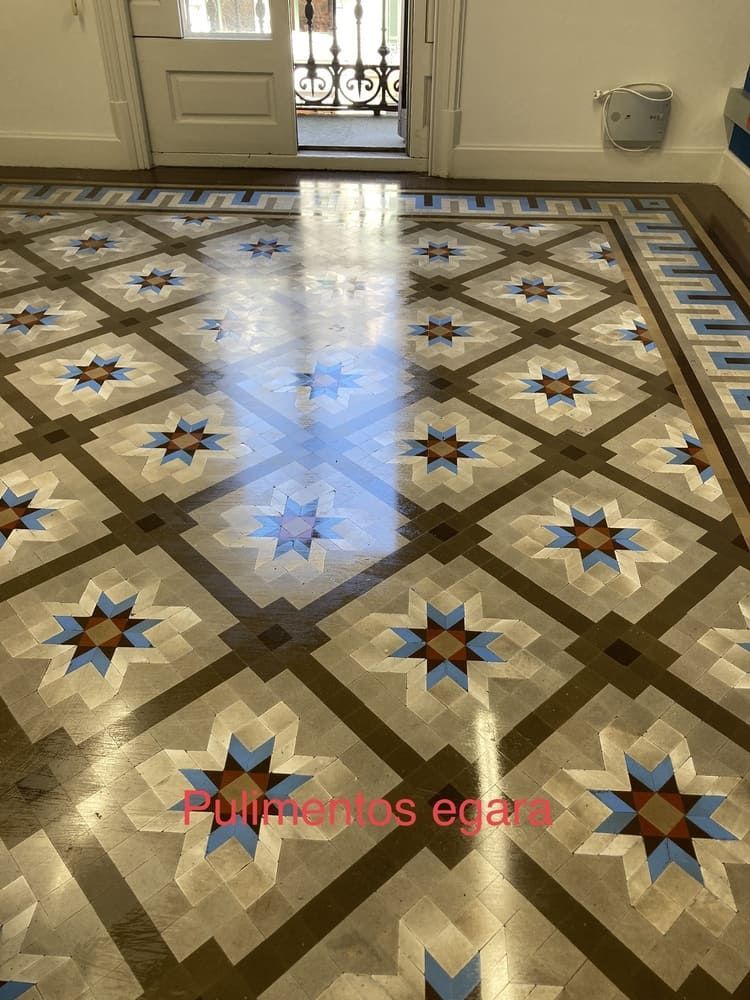 Un suelo de baldosas con un patrón geométrico y una puerta al fondo.