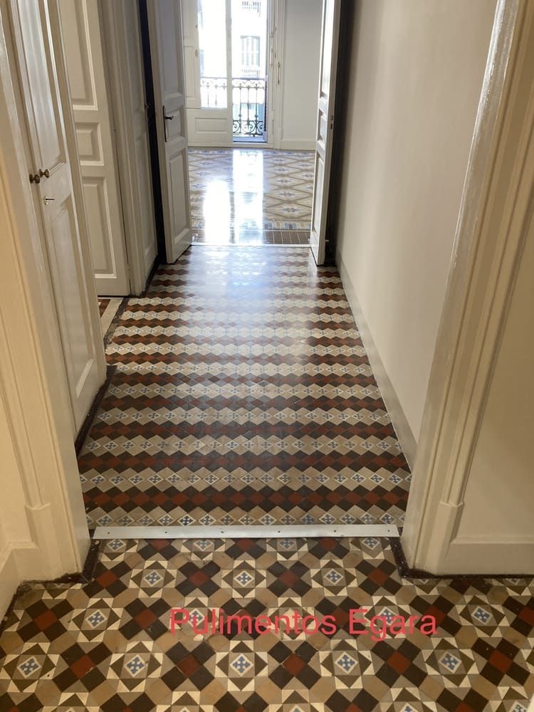 Un pasillo con suelo de baldosas y una puerta que da a un balcón.