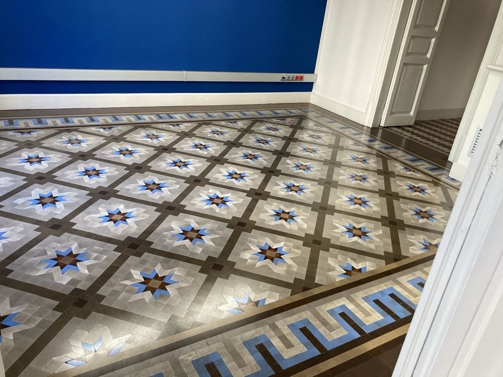 Una habitación con suelo de baldosas y una pared azul.