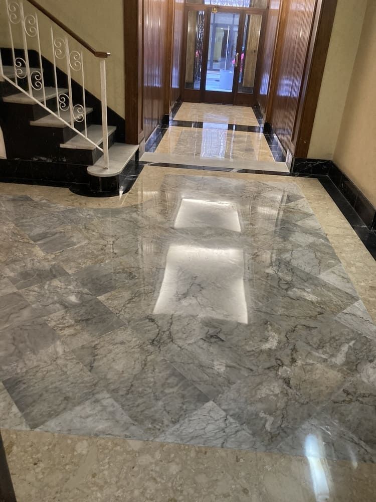 Un pasillo con escaleras y suelo de mármol.