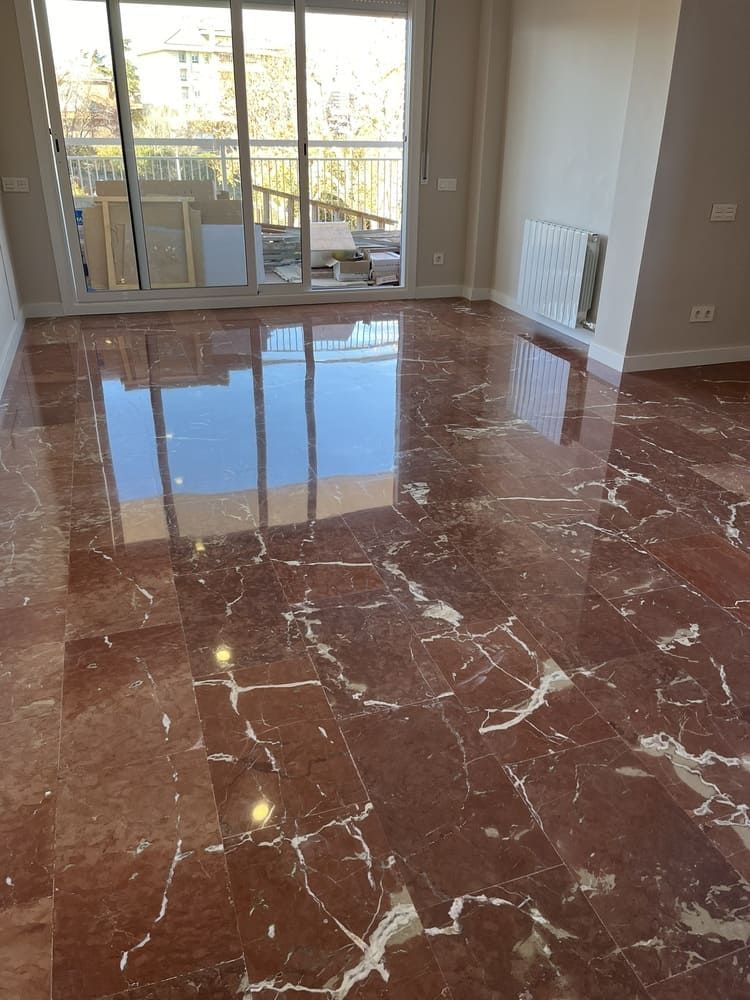 Una sala de estar con piso de mármol y puertas corredizas de vidrio.