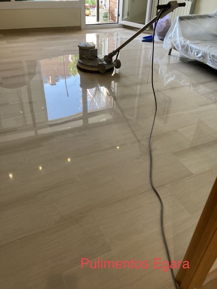 Una aspiradora está colocada sobre un suelo de baldosas en una sala de estar.