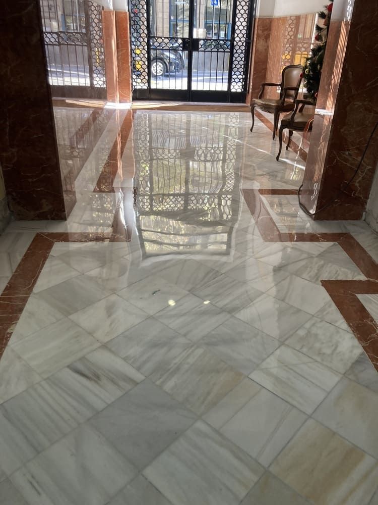 Un suelo de mármol con el reflejo de una puerta.