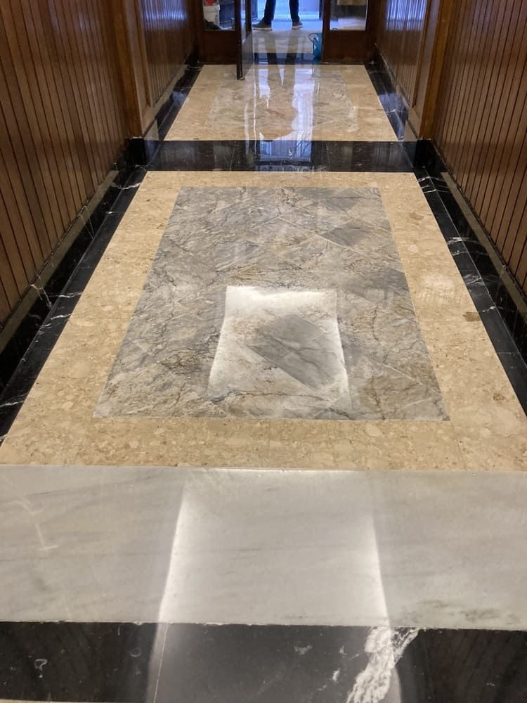 Un pasillo con suelo de mármol y pared de madera.