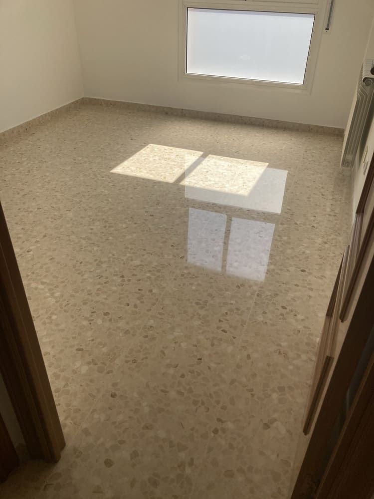 Una habitación con suelo de mármol y una ventana.