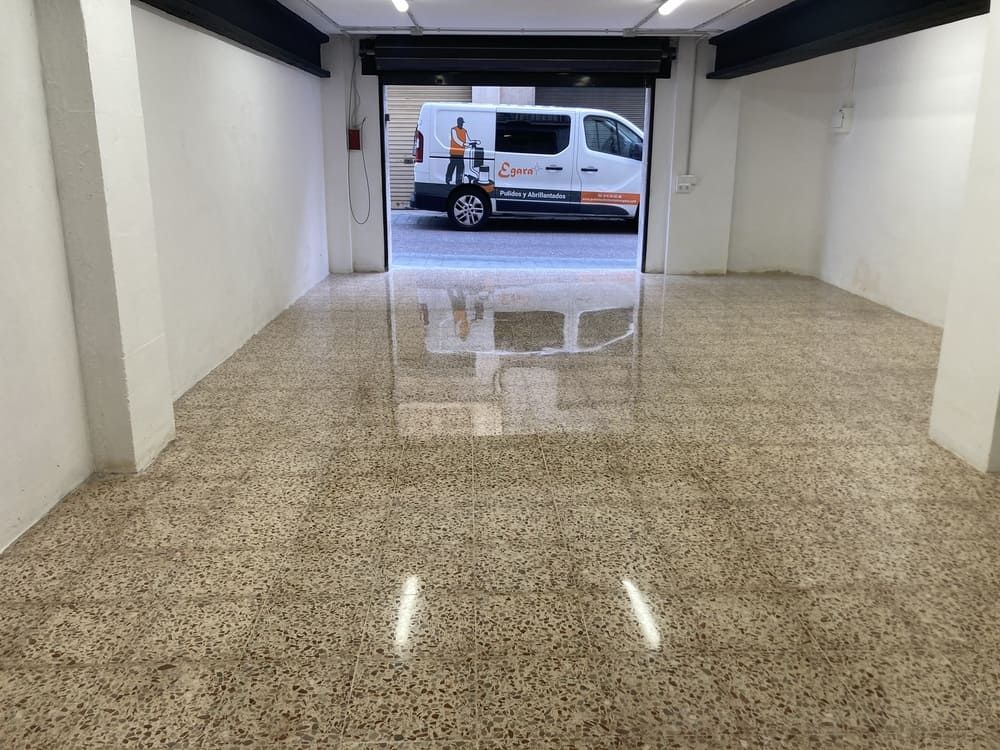 Una furgoneta está aparcada en un garaje con la puerta abierta.