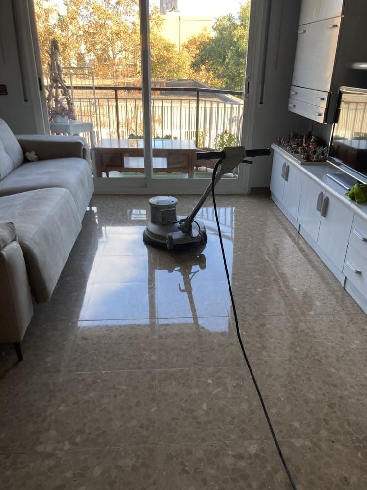 Una aspiradora está colocada sobre un suelo de mármol en una sala de estar.