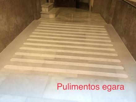 Un suelo de mármol con rayas blancas en un pasillo.