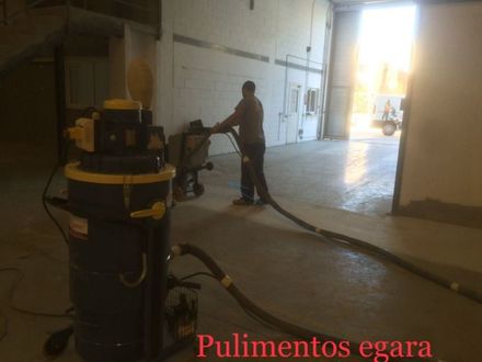 Un hombre está usando una aspiradora en una habitación vacía.