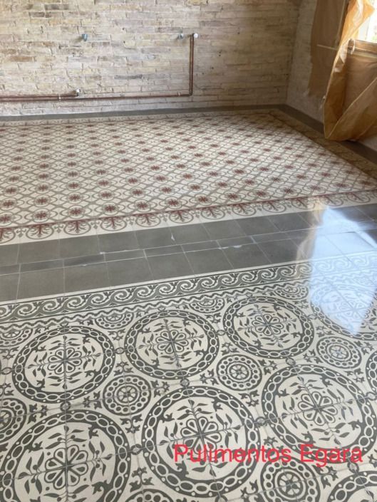 Una habitación con suelo de baldosas y una pared de ladrillo.
