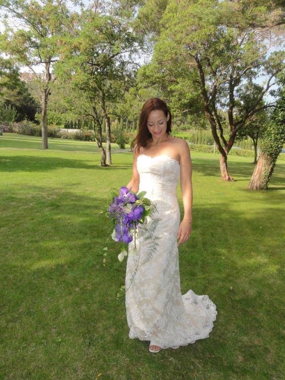 Une mariée qui tient un bouquet violet de face