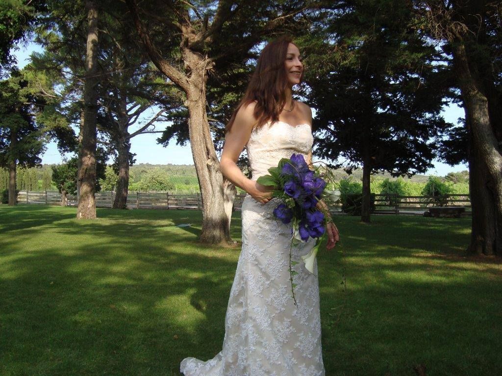 Une mariée qui tient un bouquet violet