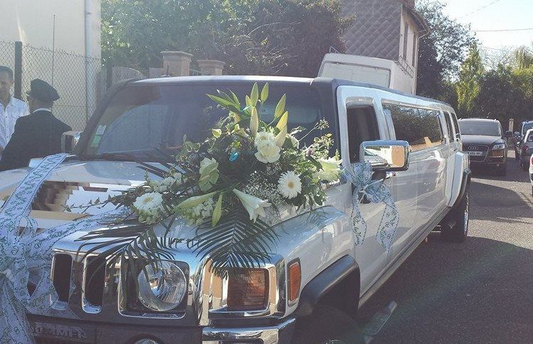 Une composition florale sur une limousine de mariage