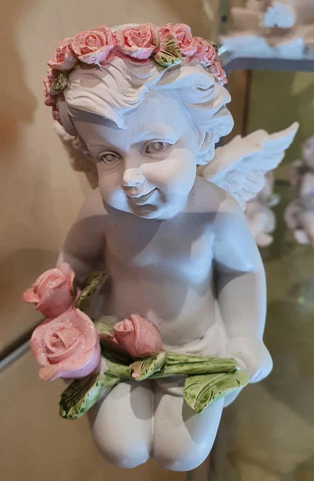 Un petit ange avec une couronne de roses