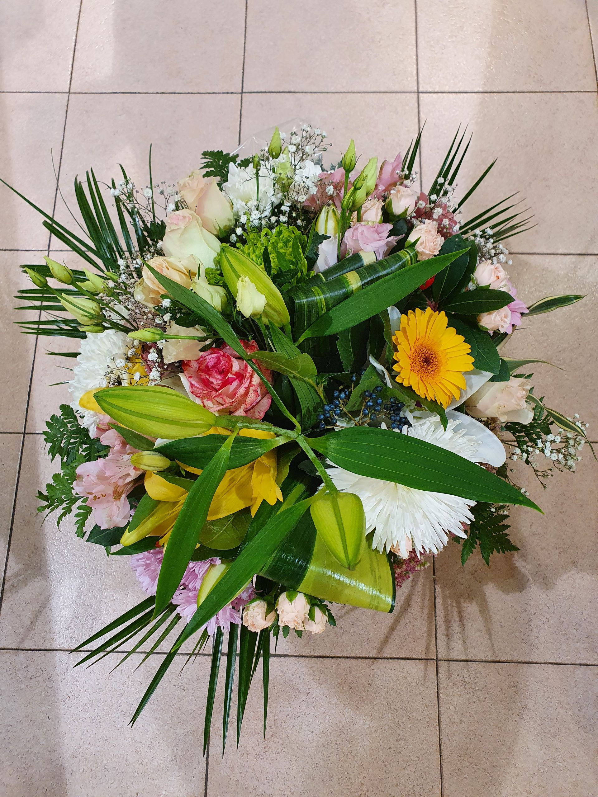 Un bouquet de lys, roses et feuilles vertes