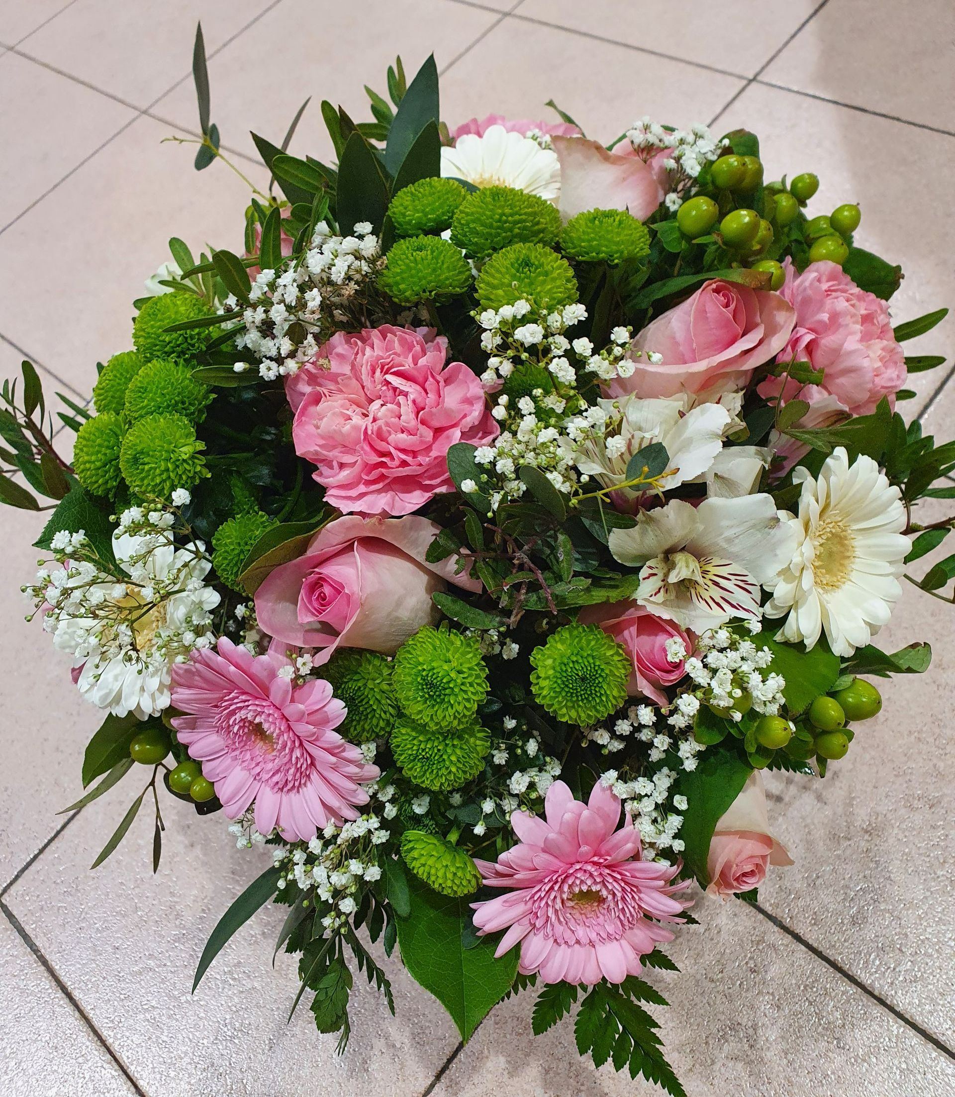 Un bouquet de fleurs roses et de baies vertes