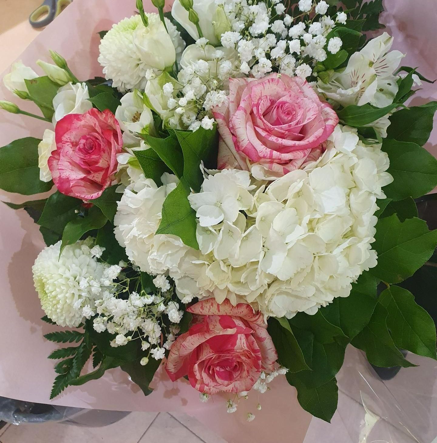 Un bouquet composé de trois roses et d'un gros hortensia blanc