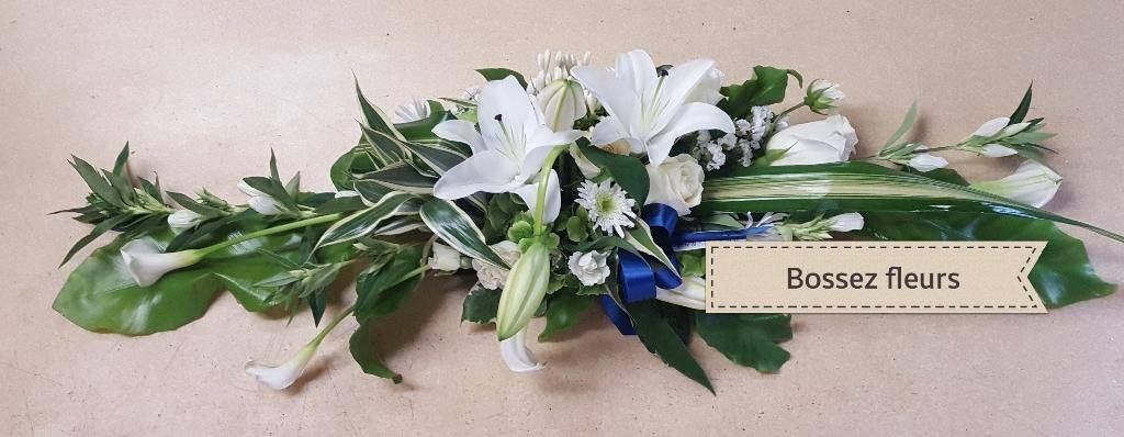 Une composition florale composée de fleurs blanches et d'un ruban bleu