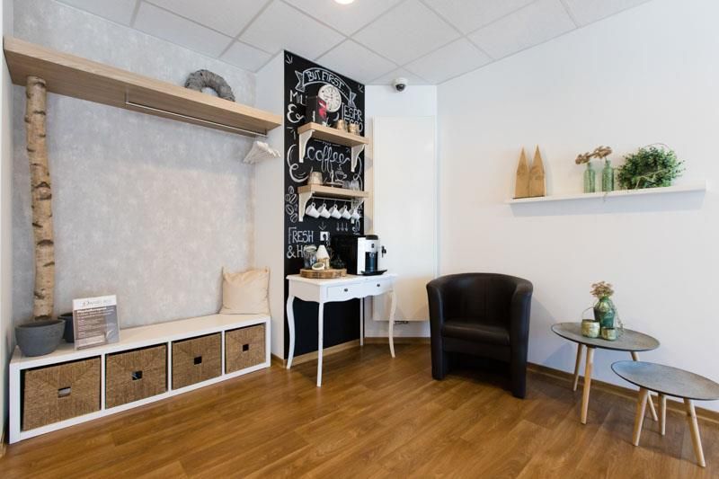 Ein Wohnzimmer mit zwei Stühlen, einem Tisch und einer Tafel.