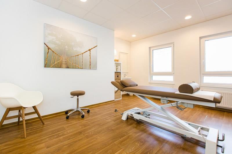In der Mitte des Raumes steht eine Massageliege.