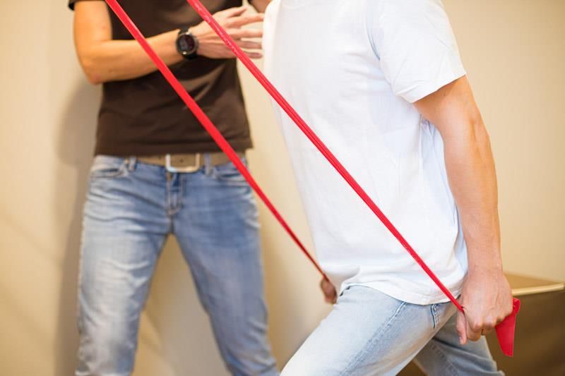 Ein Mann macht Übungen mit einem roten Widerstandsband