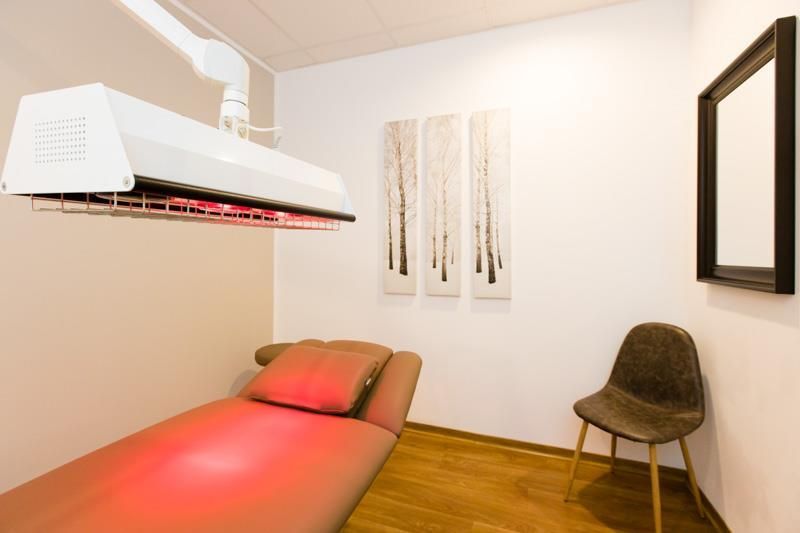 Ein Zimmer mit einem Bett, einem Stuhl und einem Spiegel.