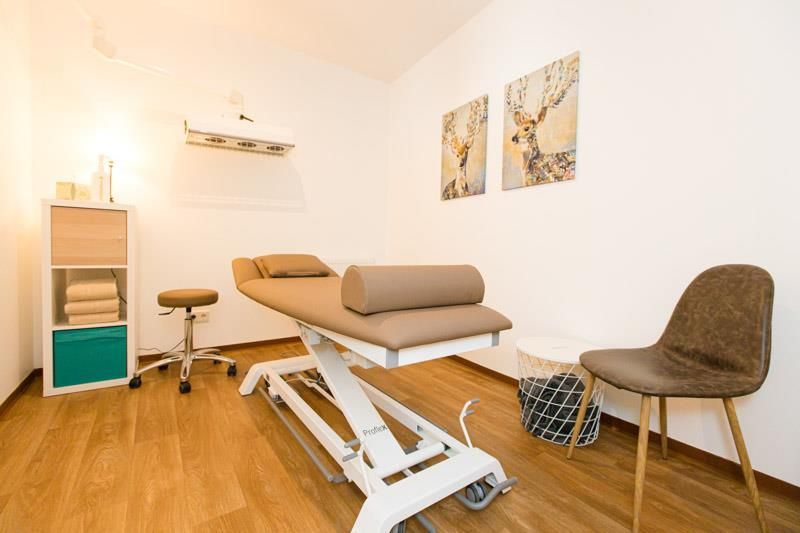 In der Mitte des Raumes steht eine Massageliege.