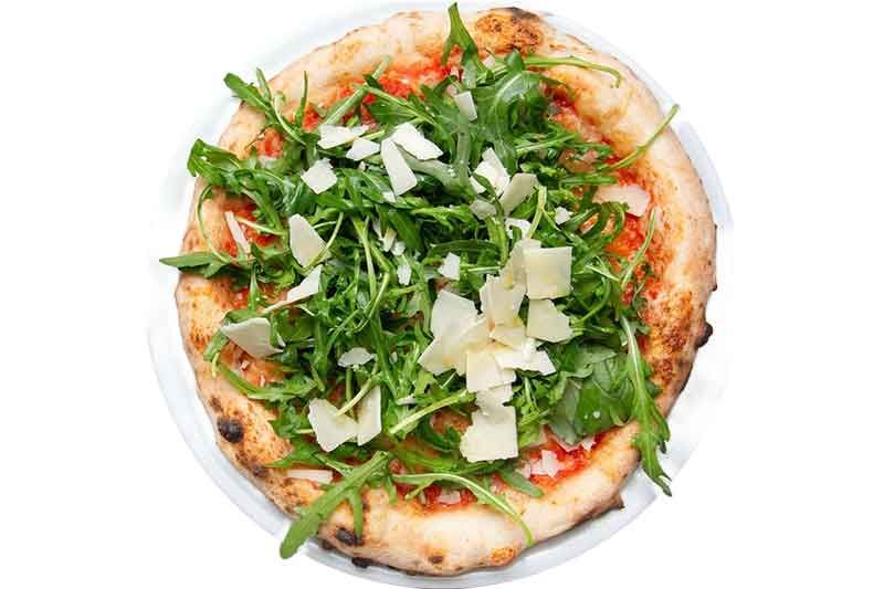 Pizza mit Rucola und Parmesan auf einem weißen Teller.