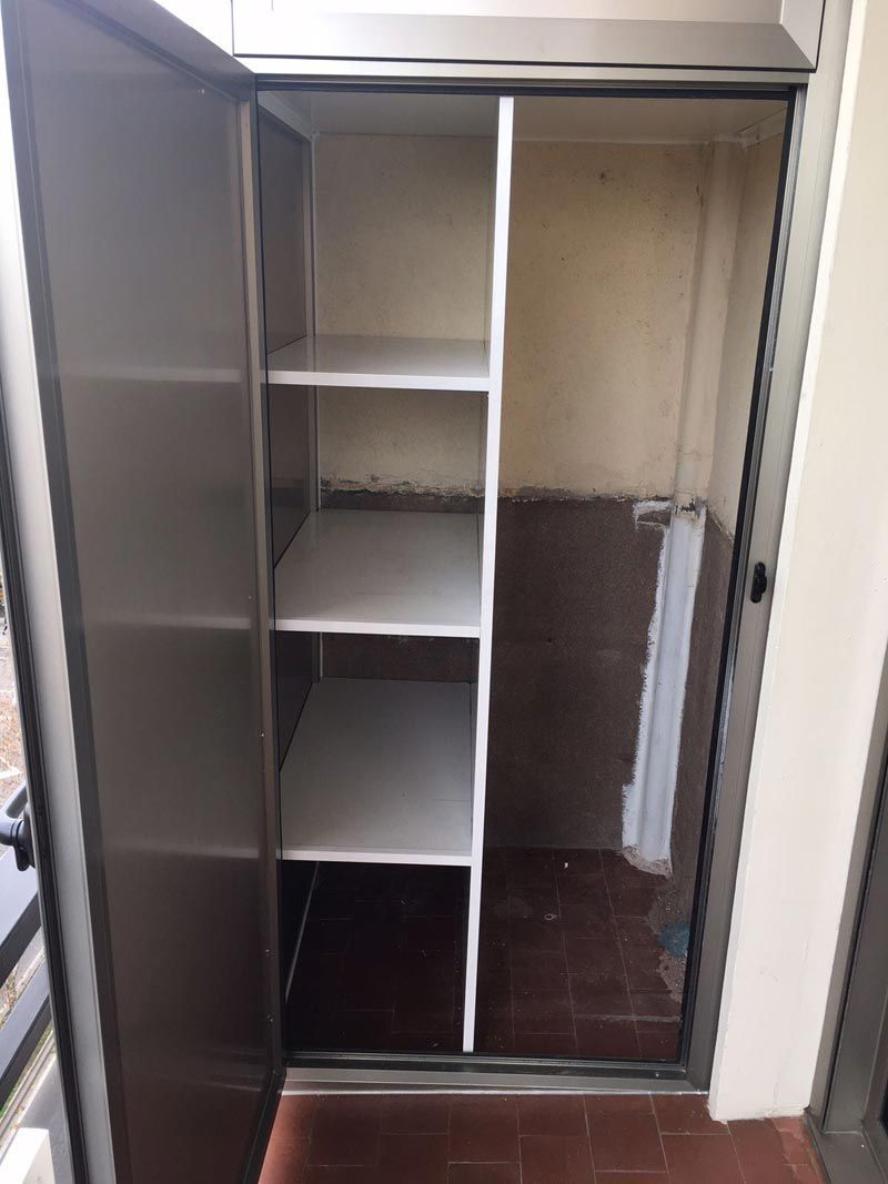 Un armario de acero inoxidable con estantes y una puerta.