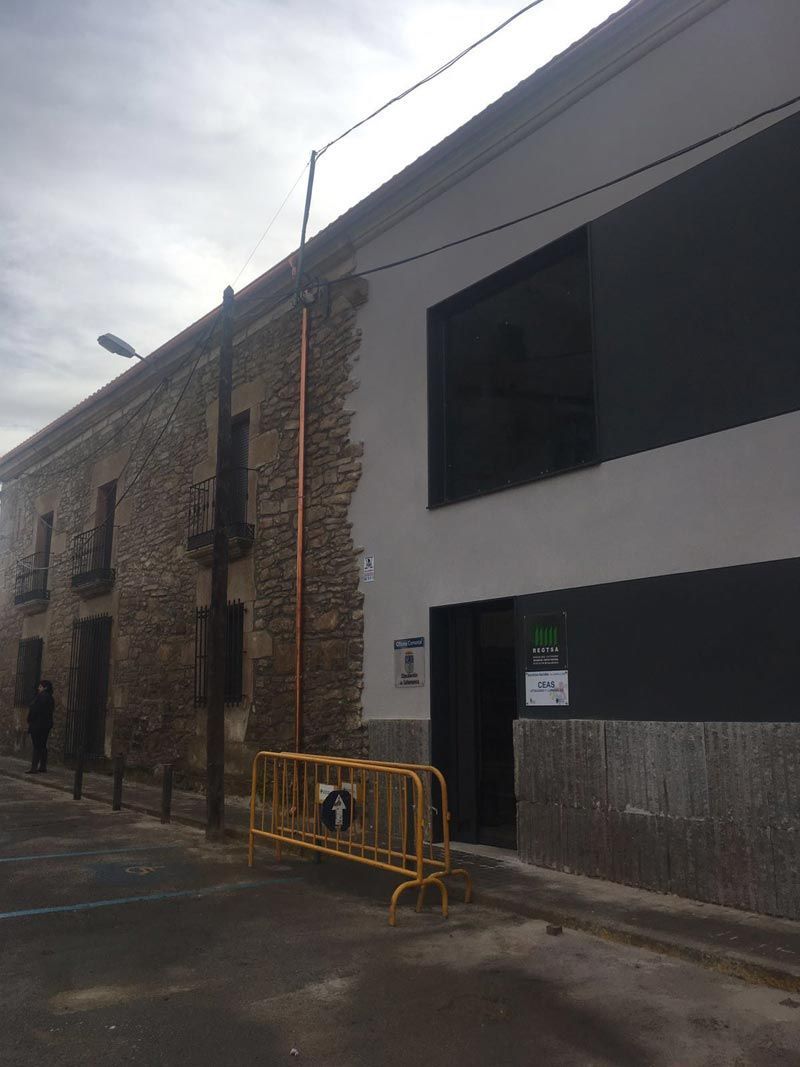 Un edificio con una barrera amarilla delante