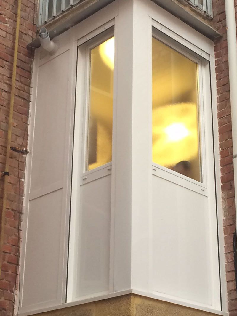 Una ventana blanca en la esquina de un edificio de ladrillo