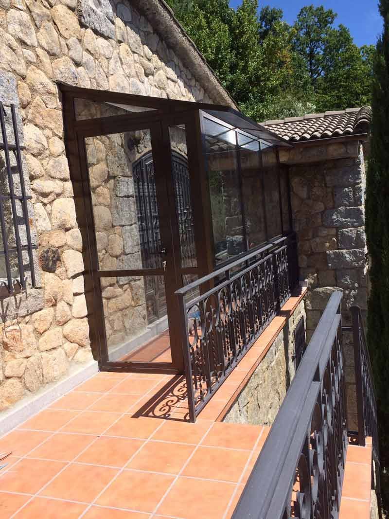 Un edificio de piedra con un balcón y una puerta de cristal.