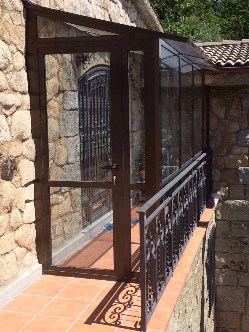 Un edificio de piedra con un balcón y una puerta de cristal.