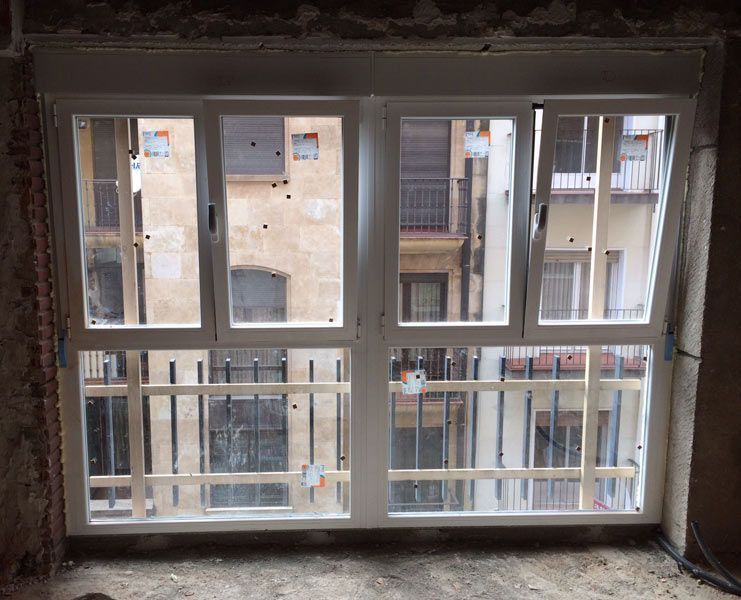 Una ventana grande en una habitación con vista a un edificio.