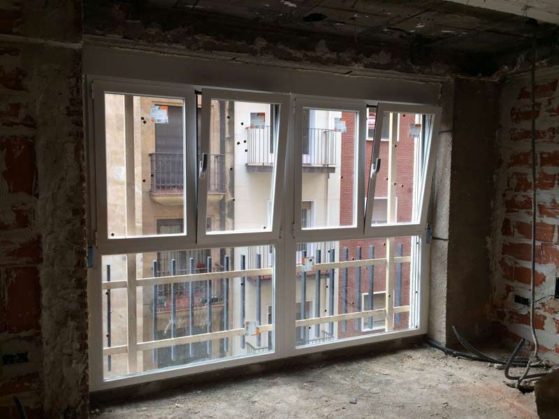 Una habitación con muchas ventanas y una pared de ladrillos.