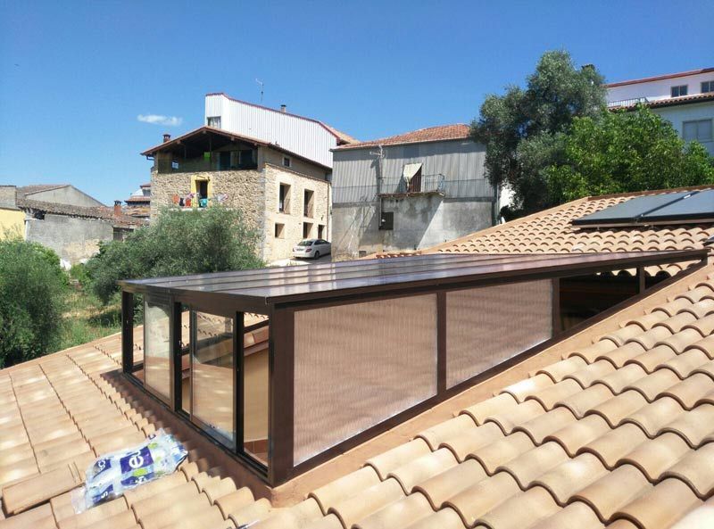 Un tejado con una gran ventana y un tejado cubierto de tejas.