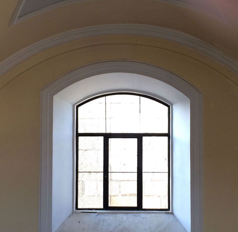 Una habitación vacía con una gran ventana arqueada