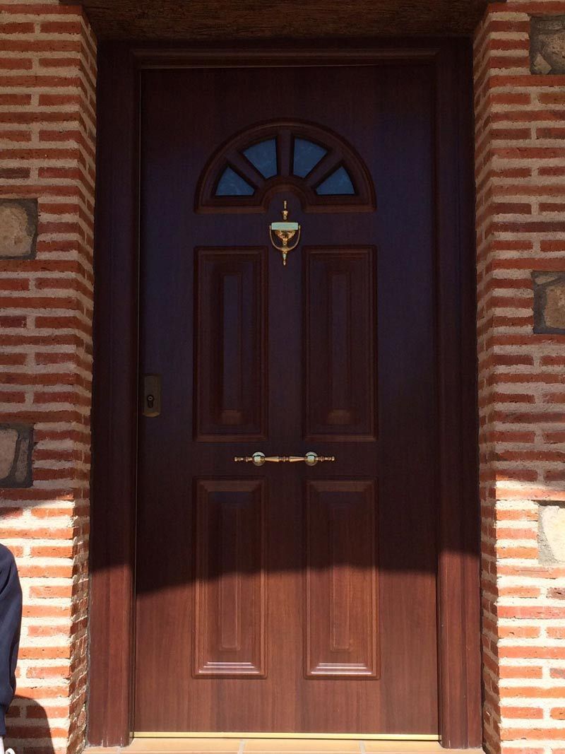 Una puerta de madera con una pared de ladrillos detrás