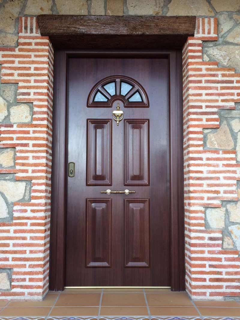 Una puerta de madera con una pared de ladrillos detrás