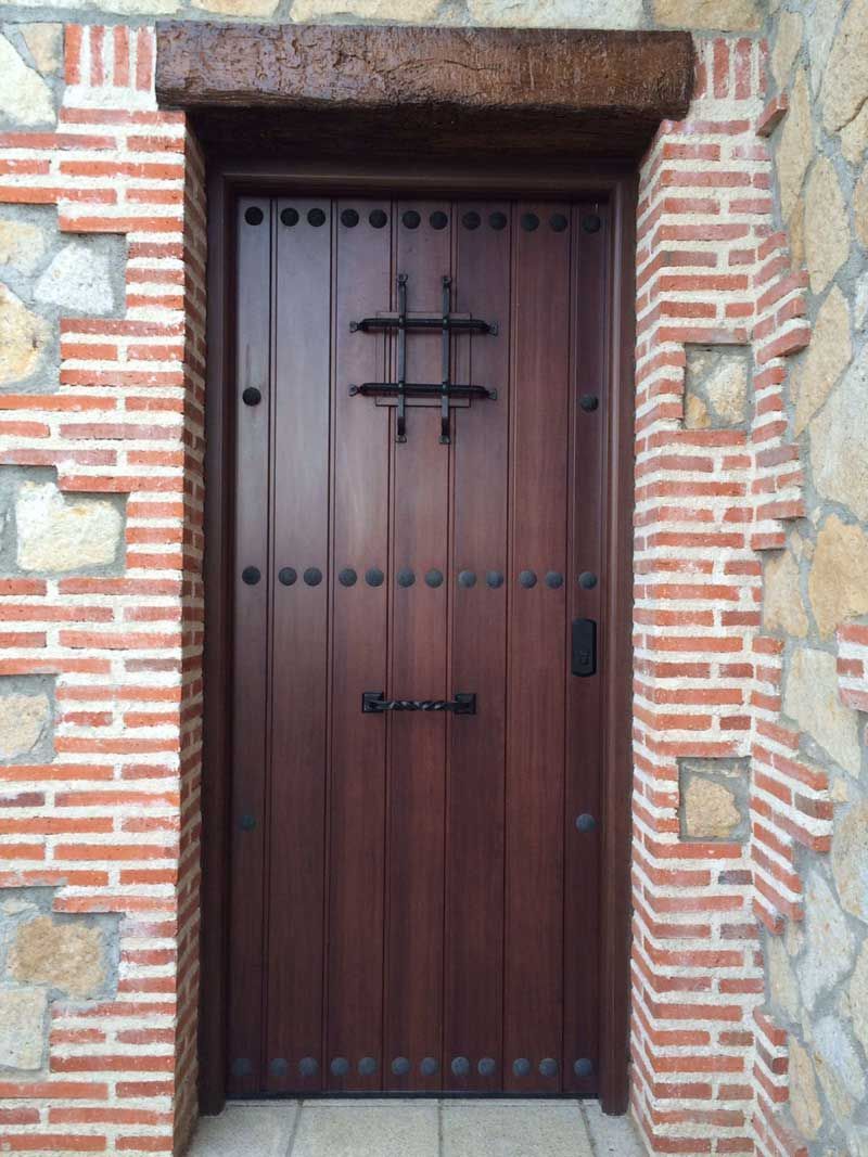 Una puerta de madera con una pared de ladrillos detrás