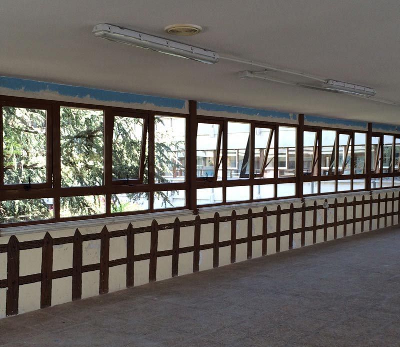 Una habitación con muchas ventanas y una valla de madera.